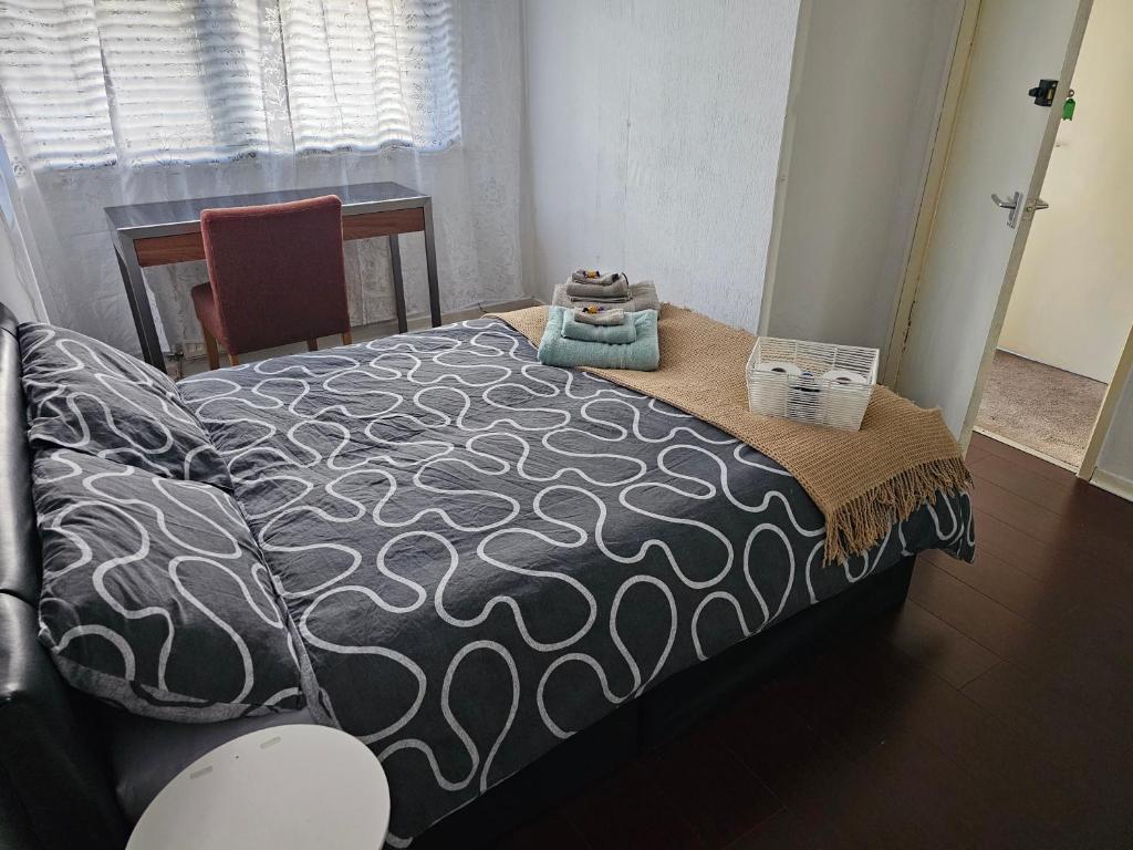 1 cama con edredón blanco y negro en una habitación en Axel's Rooms 1, en Mánchester