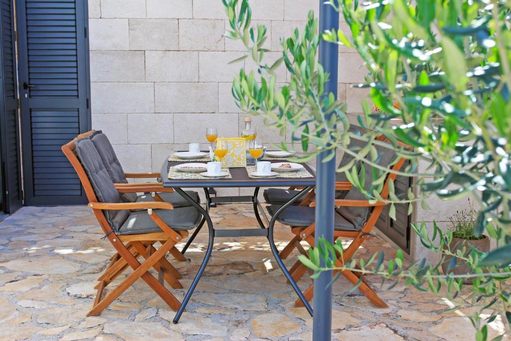 a table and two chairs with food on it at Apartment Limoni in Sutivan