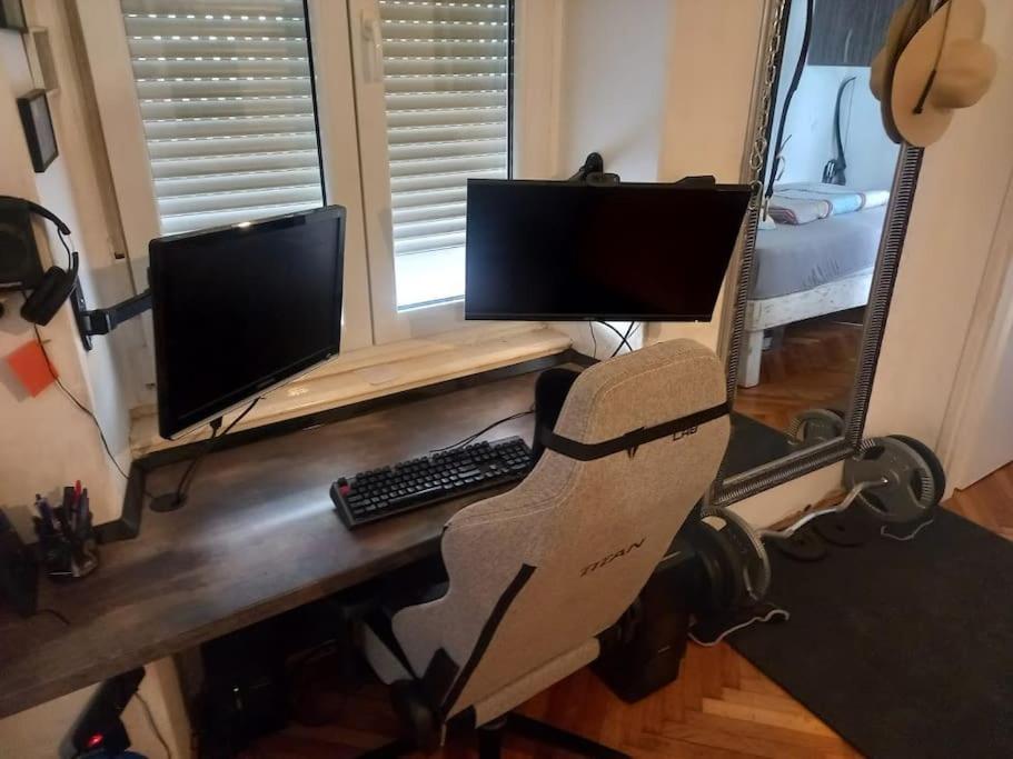 escritorio con monitor de ordenador y teclado en Comfy Apartment in Rijeka center en Rijeka