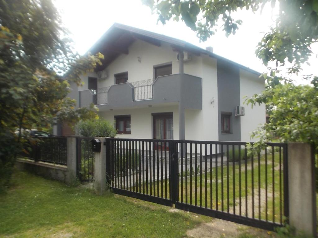 een wit huis met een hek ervoor bij Kuća za odmor V&E in Bihać