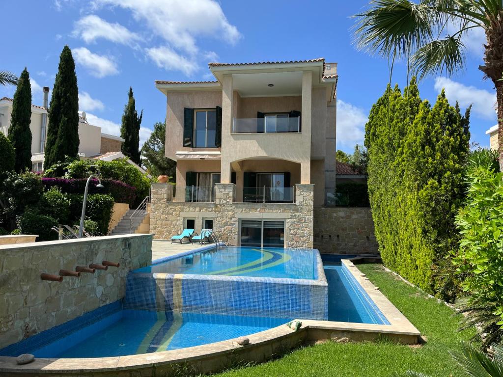 una villa con piscina frente a una casa en Amorosa Beach Villa 14, en Neo Chorio