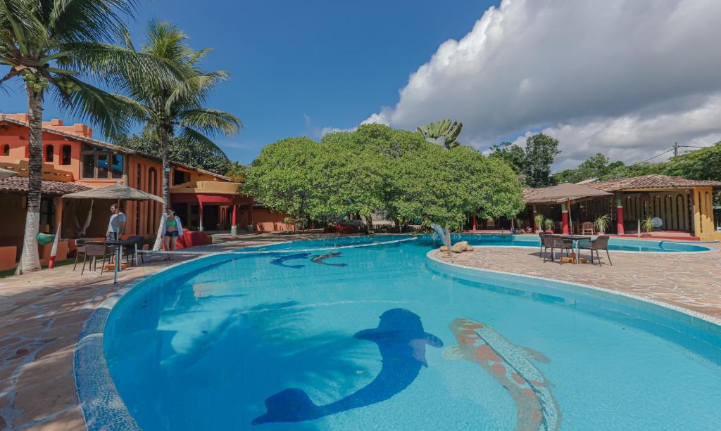 uma grande piscina num resort com pessoas ao fundo em Estação Santa Fé Hotel e Pousada em Arraial d'Ajuda