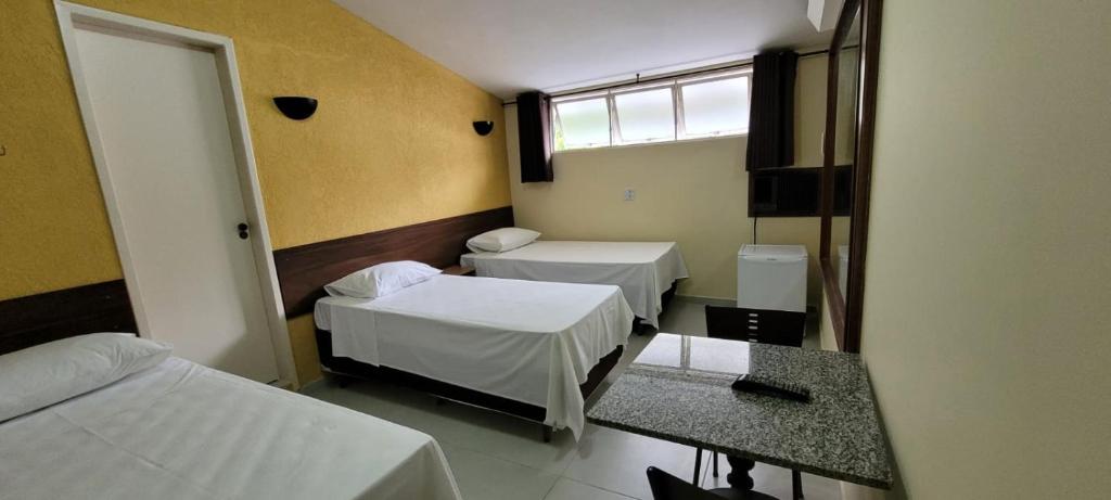 a hotel room with two beds and a window at Sleep Suites in Belo Horizonte