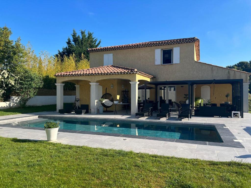 a house with a swimming pool in front of a house at Villa Provençal in La Roque-dʼAnthéron