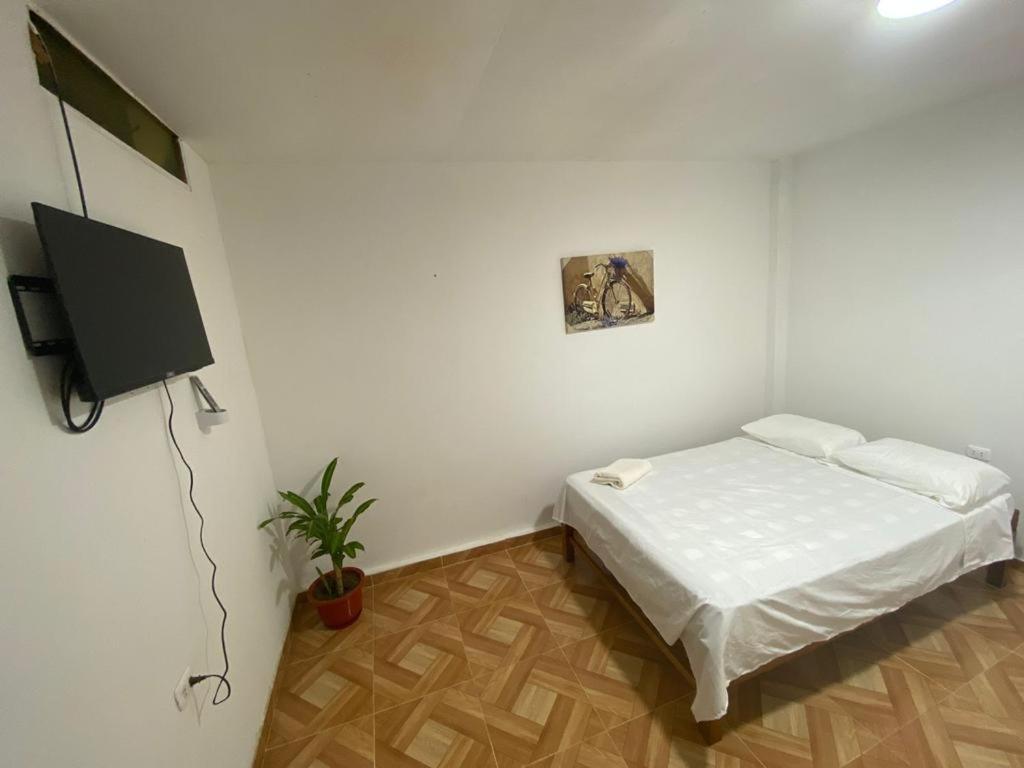 sypialnia z łóżkiem i telewizorem z płaskim ekranem w obiekcie BOCARENA w mieście Bocapán