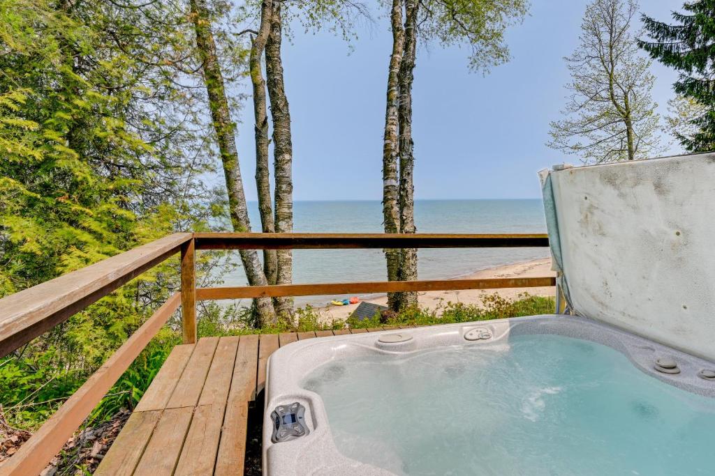 einen Whirlpool auf einer Terrasse mit Meerblick in der Unterkunft Beachy Palms Cottage on Lake Huron with Hot Tub! in Palms