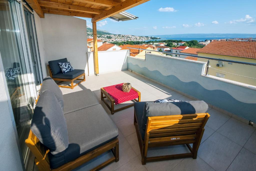 einen Balkon mit Stühlen und Stadtblick in der Unterkunft Sunny Apartments in Stobreč