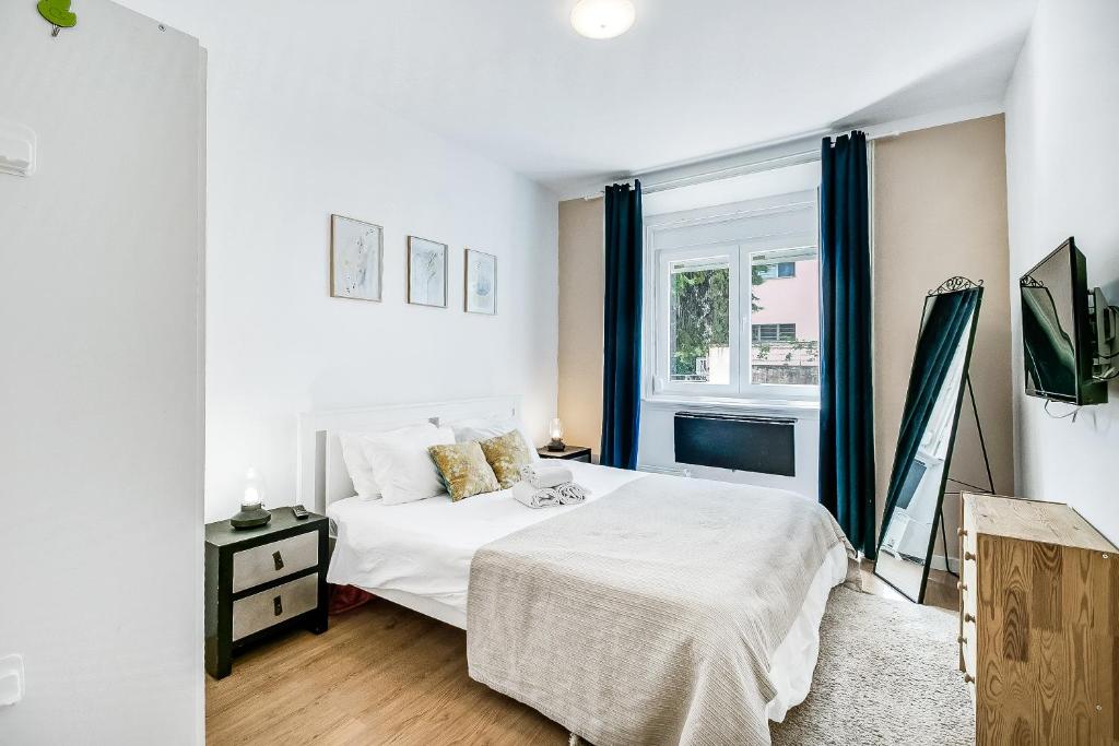 1 dormitorio con cama blanca y ventana en Lisboa Charming Apartment III en Lisboa
