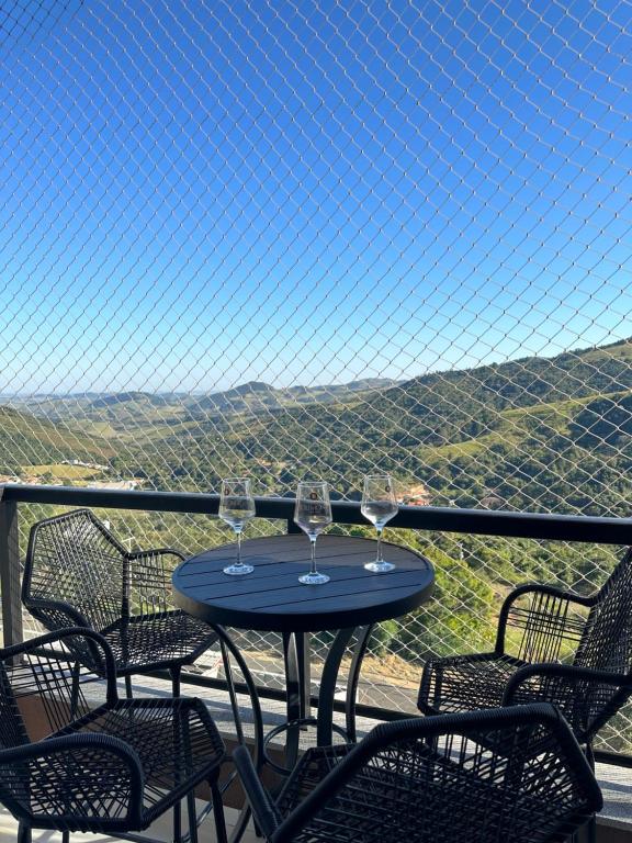 - une table avec des verres à vin sur un balcon avec vue dans l'établissement A Melhor vista de água de Lindóia, à Águas de Lindóia
