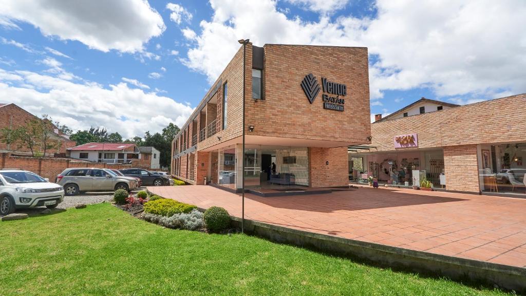 a brick building with a parking lot in front of it at Venue Hotel in Cuenca