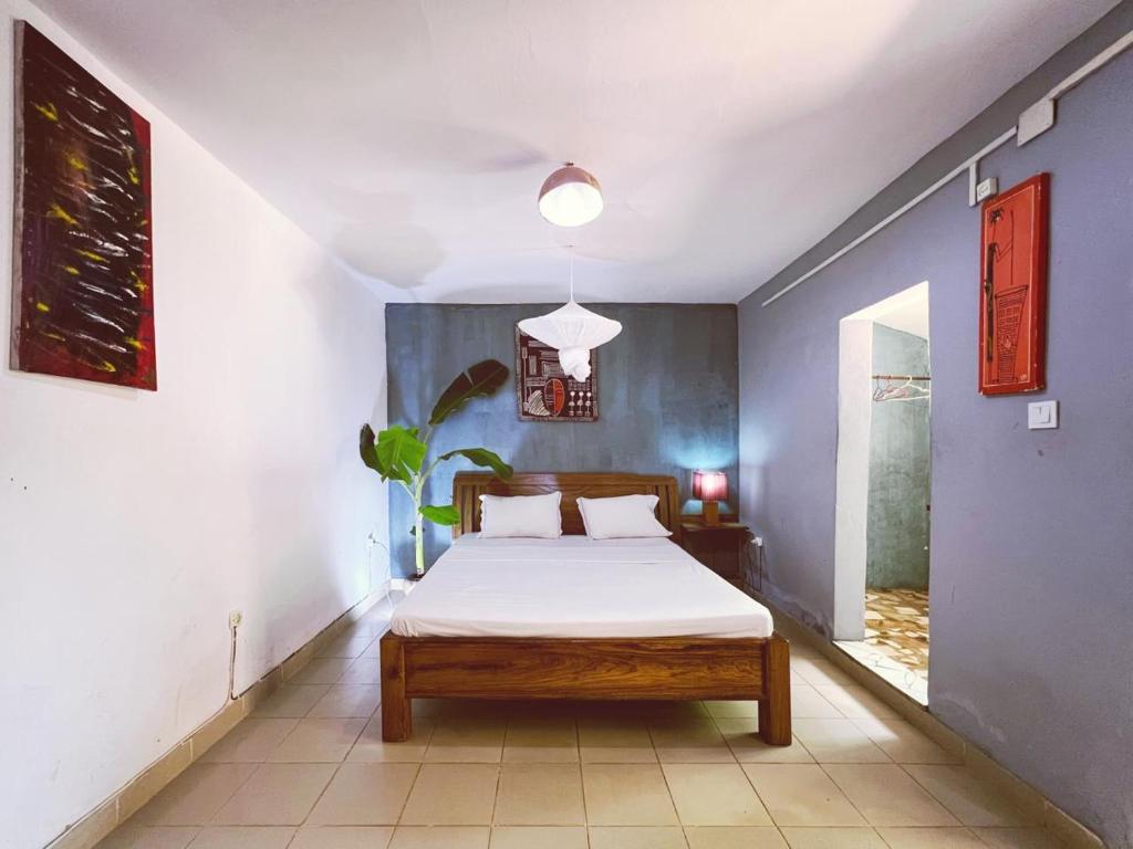 a bedroom with a bed and a blue wall at Casa Cacheu low cost family house in Bissau
