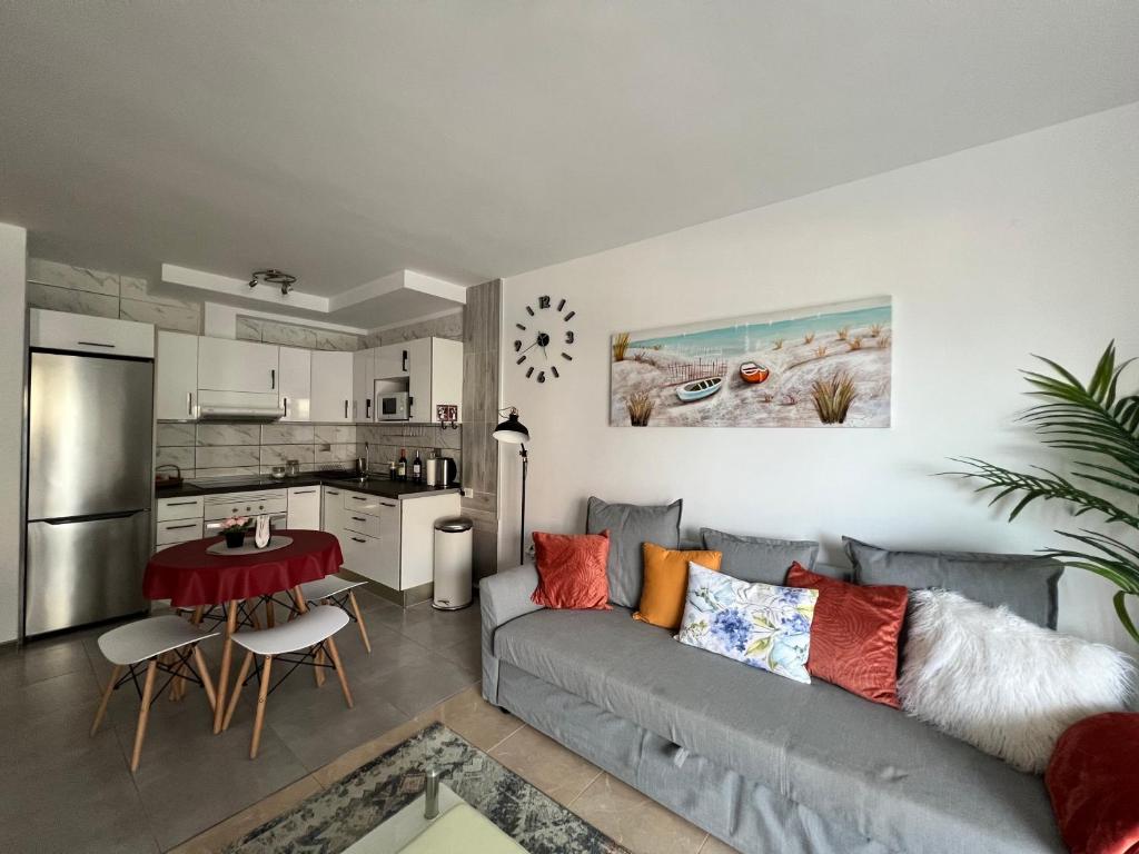 een woonkamer met een grijze bank en een keuken bij Aloha - Costa del Silencio in Arona