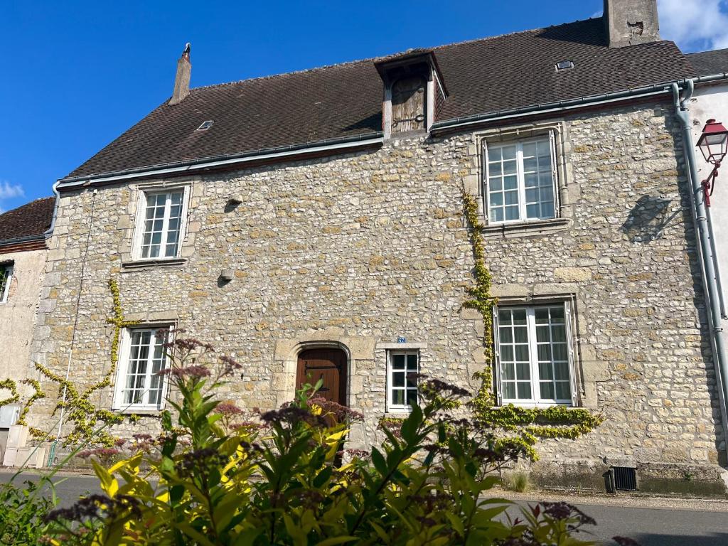 une ancienne maison en pierre avec un toit noir dans l'établissement Maison de charme, grand SPA JACUZZI, WIFI Fibre & Netflix, 