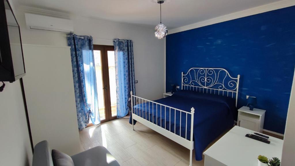 a blue bedroom with a crib and a blue wall at Casa vacanze Tortolì in Tortolì