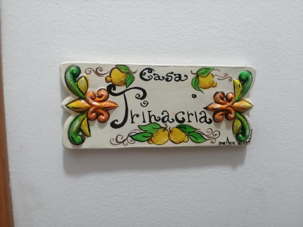 une plaque sur une paroi avec un signe sur celle-ci dans l'établissement Casa Trinacria, à Misterbianco