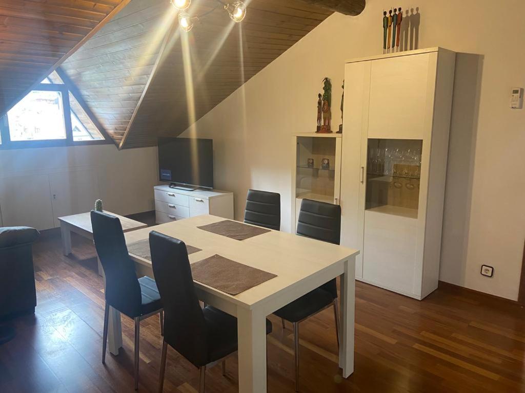 a dining room with a white table and chairs at APARTAMENT BETTY in Sort