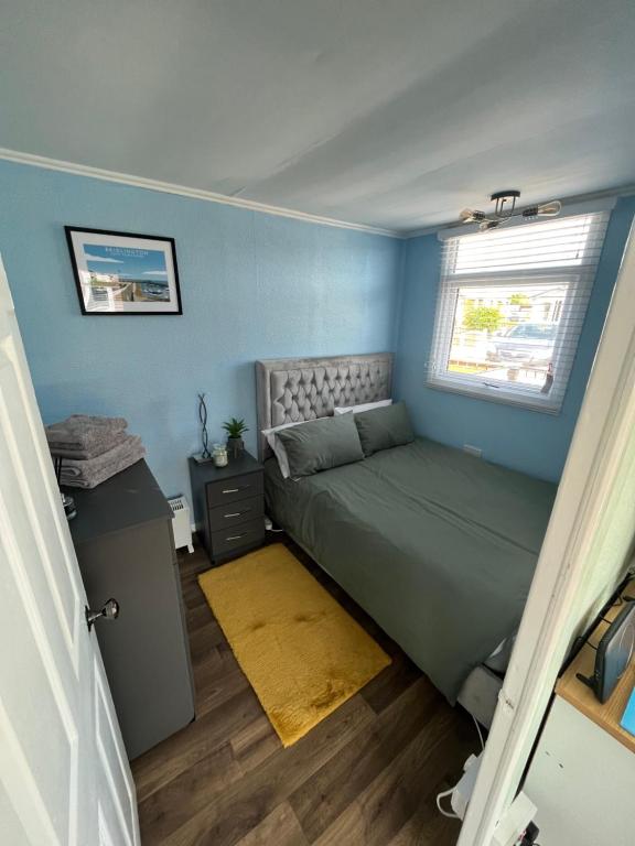 um pequeno quarto com uma cama e uma janela em Once Upon a Tide - Bridlington Chalet em Bessingby