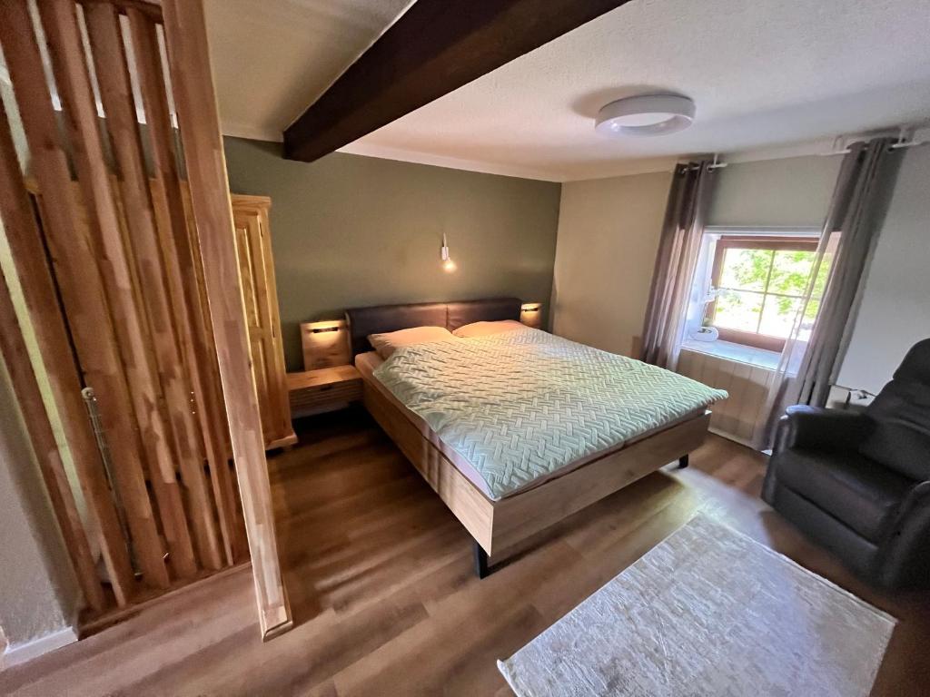 1 dormitorio con 1 cama y 1 silla en Suite SZ-Lichtenberg, en Salzgitter