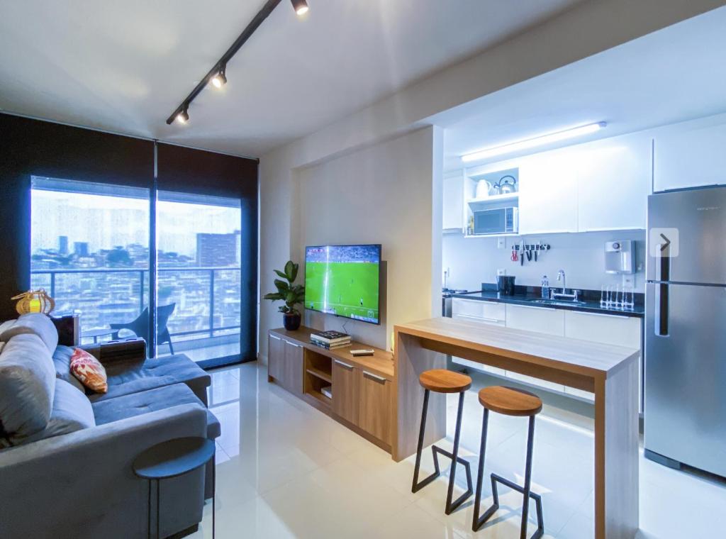 cocina y sala de estar con sofá y barra. en Apartamento moderno completo, en Río de Janeiro