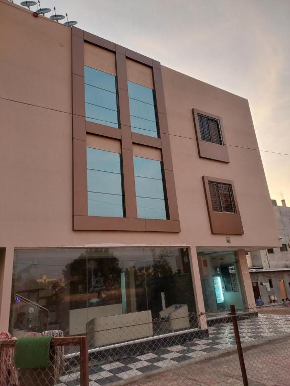 a large building with glass windows on a street at Hotel Sai Dakshina Inn in Shirdi