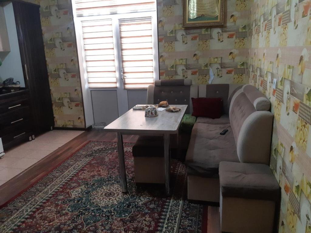 sala de estar con mesa y sofá en Квартира для 5 человек в Нукусе, en Nukus