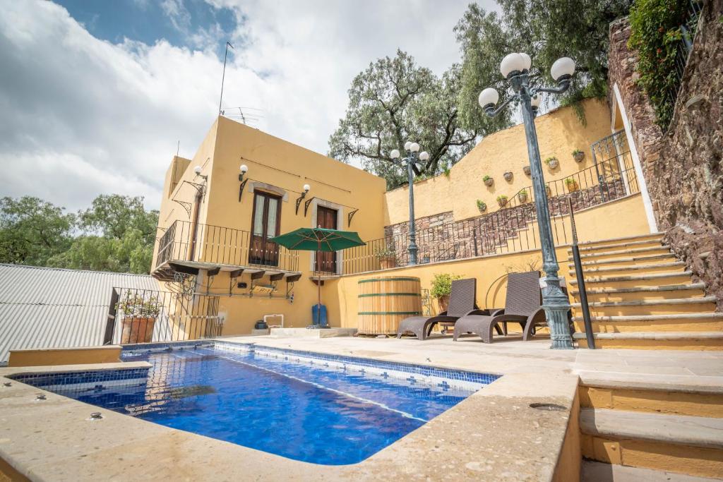 ein Haus mit einem Pool vor einem Gebäude in der Unterkunft Quinta Las Acacias Hotel Boutique in Guanajuato