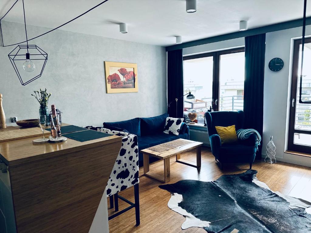 Il comprend une cuisine et un salon avec une table et des chaises. dans l'établissement Bovis APARTMENT - Gdynia Center Rezydencja Redłowo, à Gdynia
