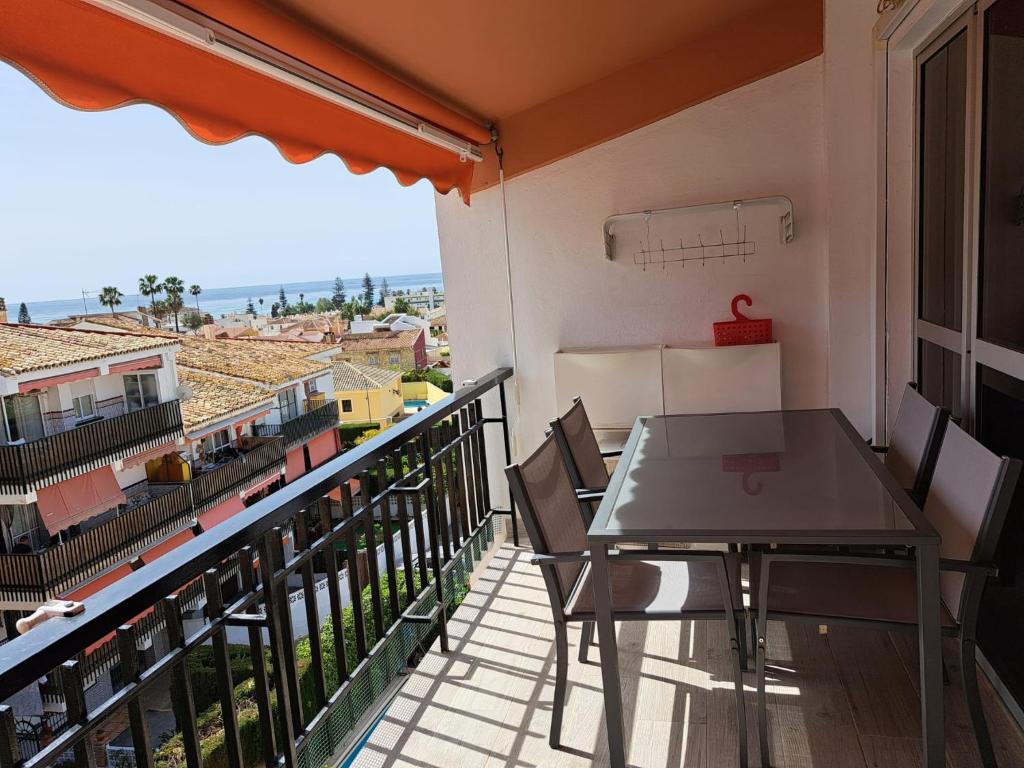 uma varanda com uma mesa e vista para o oceano em Apartamento con encanto y vistas al mar em Torre de Benagalbón