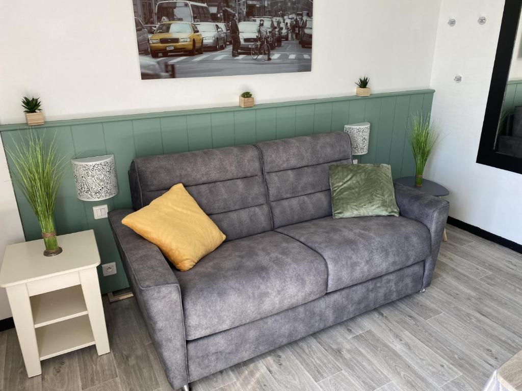 um sofá com duas almofadas numa sala de estar em VUE MER POUR 4 PERSONNES em Guidel