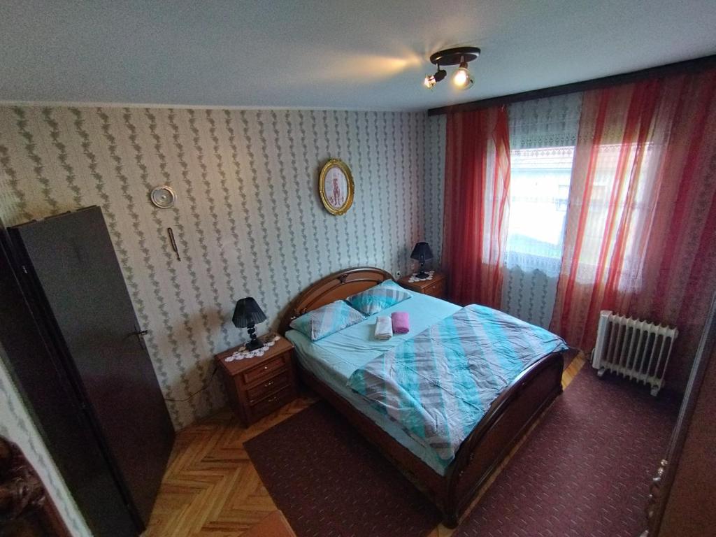 a small bedroom with a bed and a window at Libero house in Smederevo
