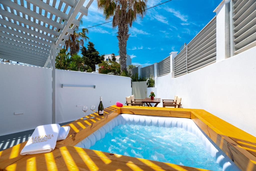 una piscina con un banco amarillo junto a un edificio en Aerenia Luxury Suites en Karterados