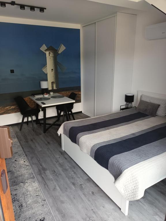 1 dormitorio con 1 cama y 1 mesa con una cruz en la pared en Basztowa Apartament, en Świnoujście