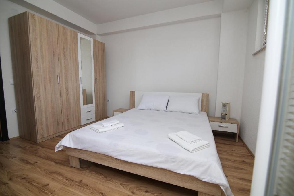 a bedroom with a white bed with two towels on it at Ohrid City Apartments in Ohrid
