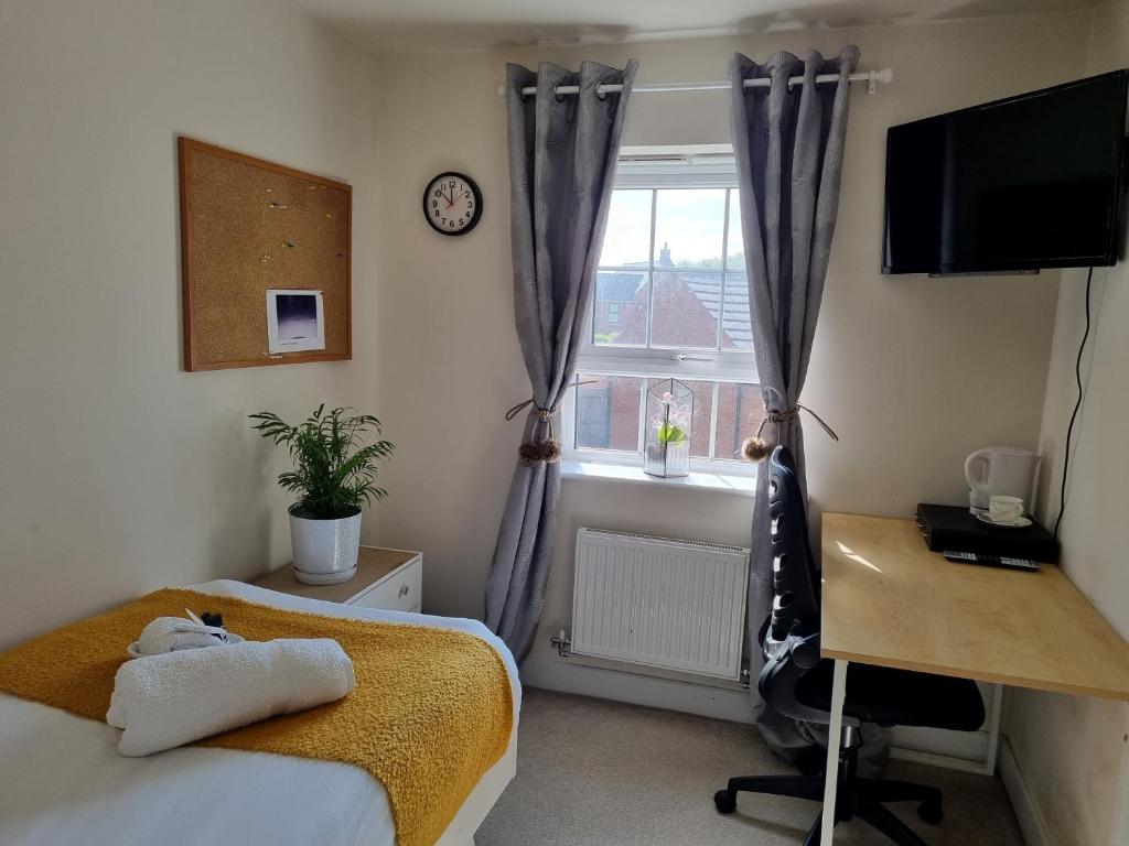 1 dormitorio con cama, escritorio y ventana en Deluxe room in a spacious house en Kirby Muxloe