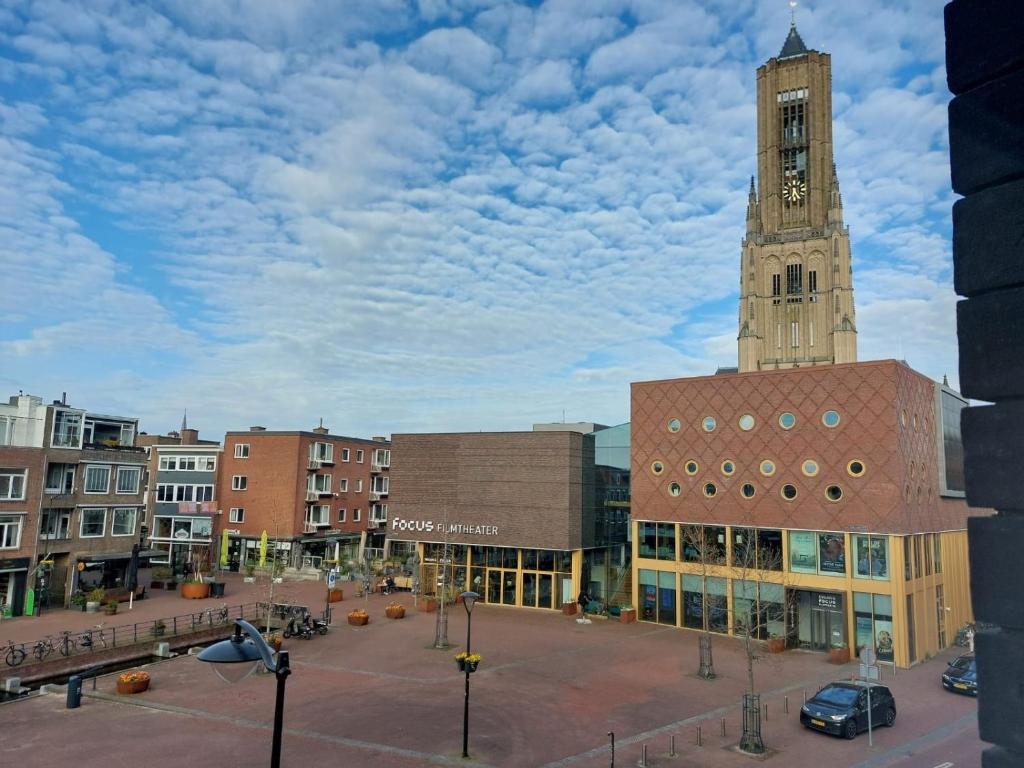 a building with a clock tower in a city at Medina B&B hartje Arnhem in Arnhem