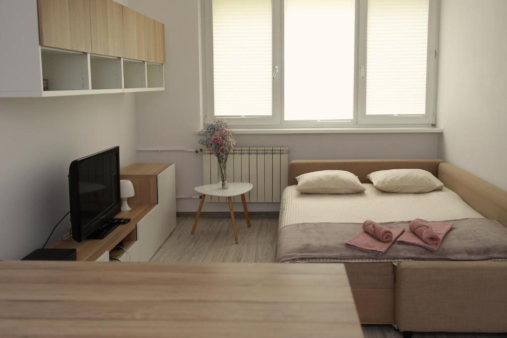 um pequeno quarto com uma cama e uma televisão em Warszawa Mieszkanie 4 em Varsóvia
