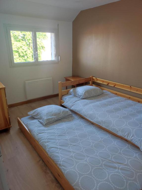 a bedroom with two twin beds in it at La petite trapue in Desvres