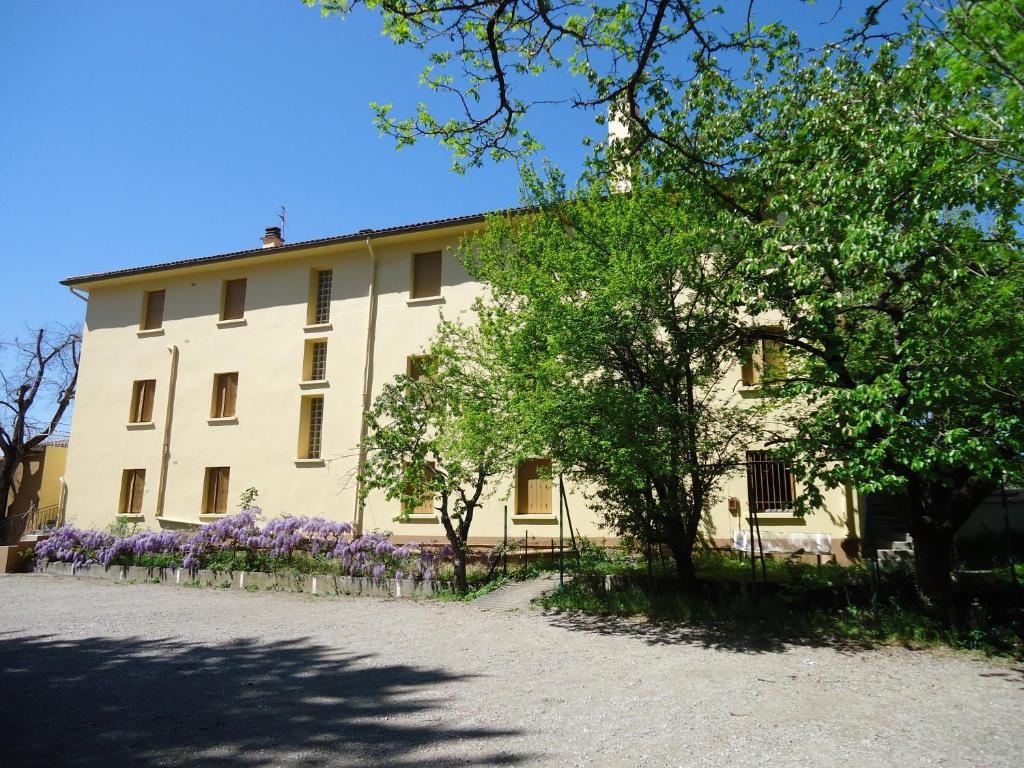 a white building with purple flowers in front of it at Hotel des Voyageurs in Millau