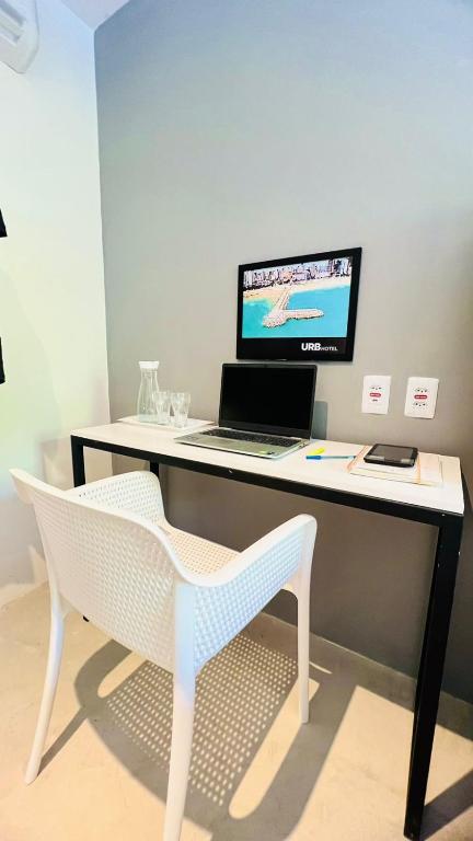 a desk with a laptop computer and a chair at URB Hotel in Fortaleza