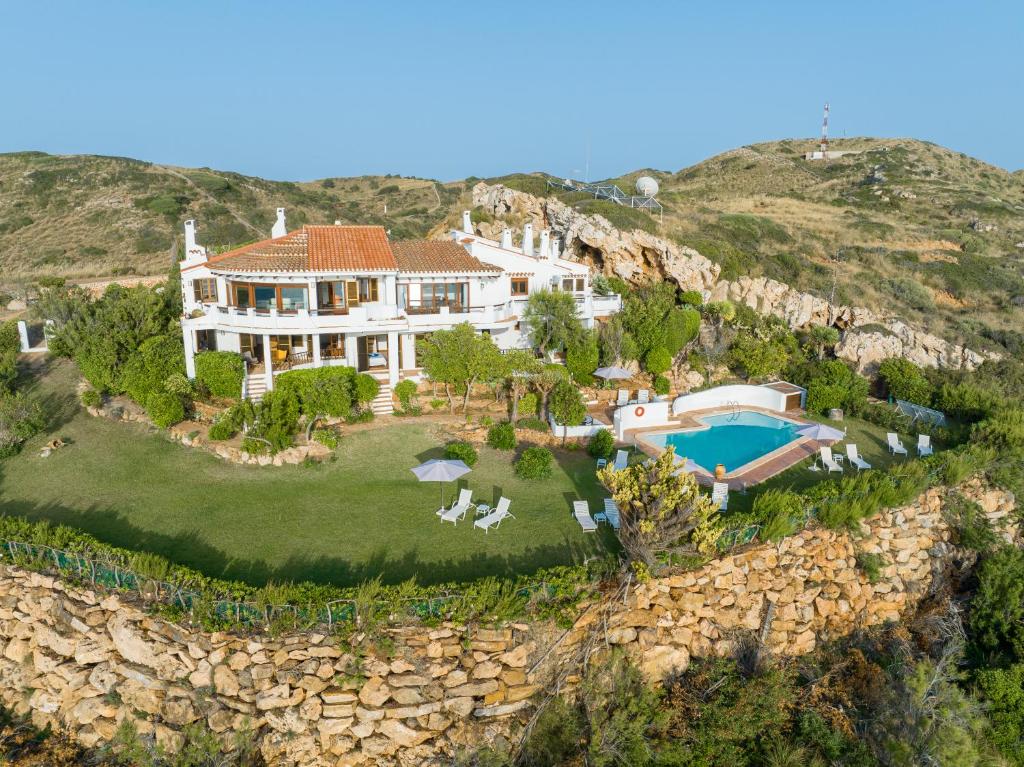 an aerial view of a house with a rock wall at Villa de lujo en Playa de Fornells in Fornells