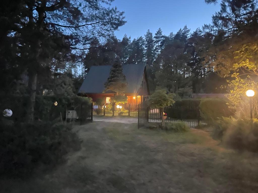 Una casa con una puerta en un patio por la noche en DOM Z BALI Villa Bajkowy Dom en Dźwierzuty