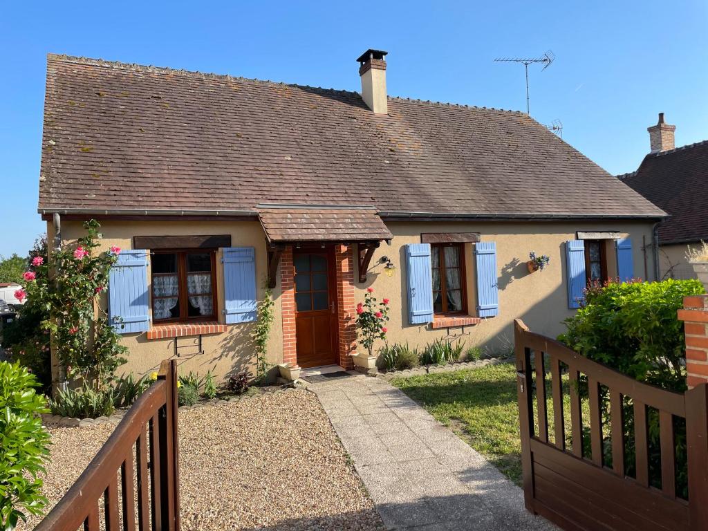 mały żółty dom z drewnianym płotem w obiekcie Gîte en Sologne w mieście Selles-Saint-Denis