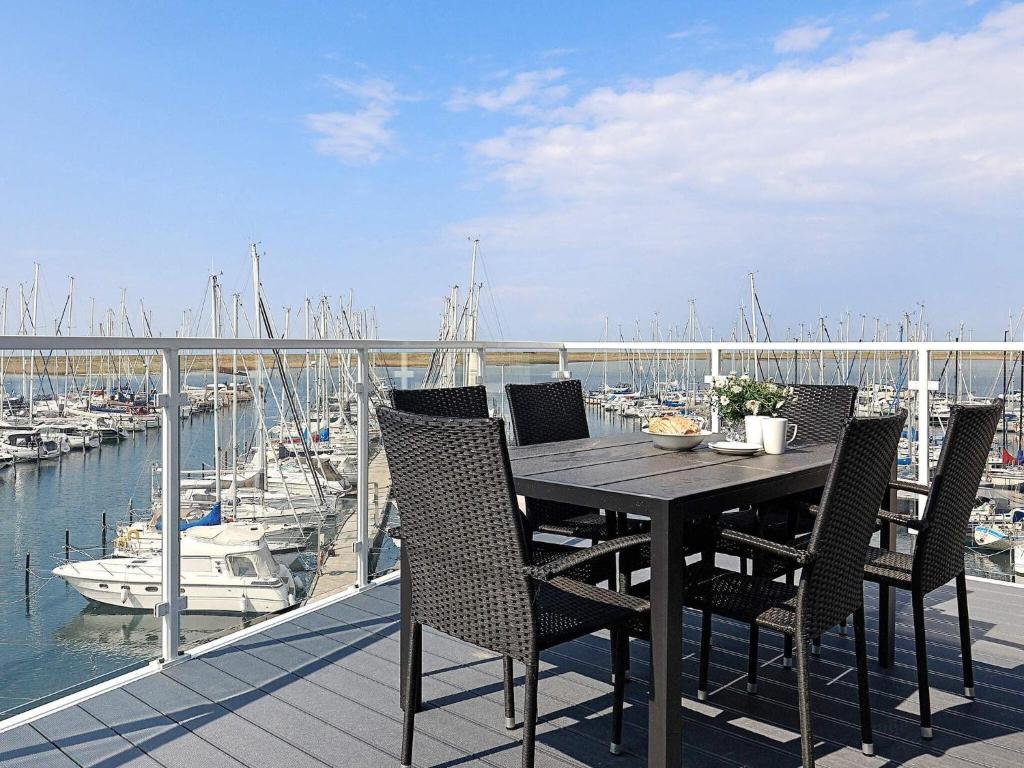 einen Tisch und Stühle auf einem Balkon mit Yachthafen in der Unterkunft Apartment with Panoramic Marina Views in Wendtorf