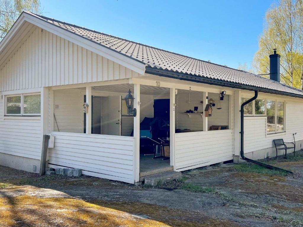 ein weißes Haus mit einer großen, offenen Veranda in der Unterkunft Holiday home VÄRMDÖ V in Värmdö