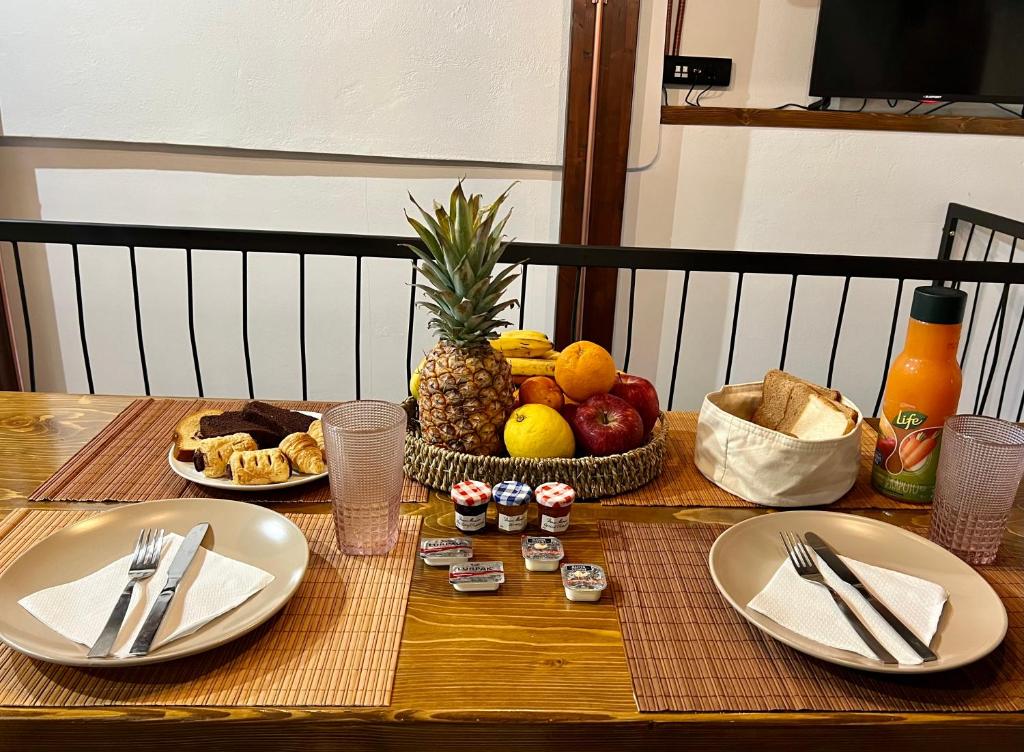 een tafel met borden eten en fruit erop bij The Stonewall House - at the old town of Samos in Vathý