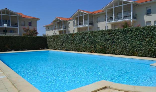 T2, bord de plage et piscine في بيسكاروس: مسبح ازرق امام بعض البيوت