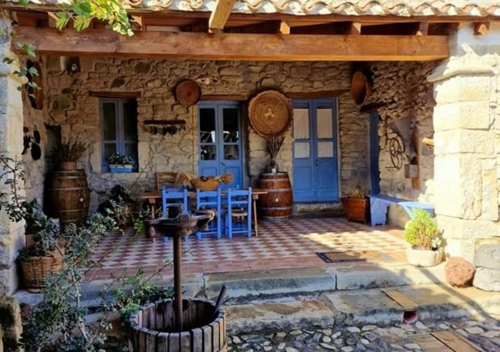 ein Steinhaus mit einer blauen Tür und einer Terrasse in der Unterkunft Sa domu de ziu Antoneddu in Tuili