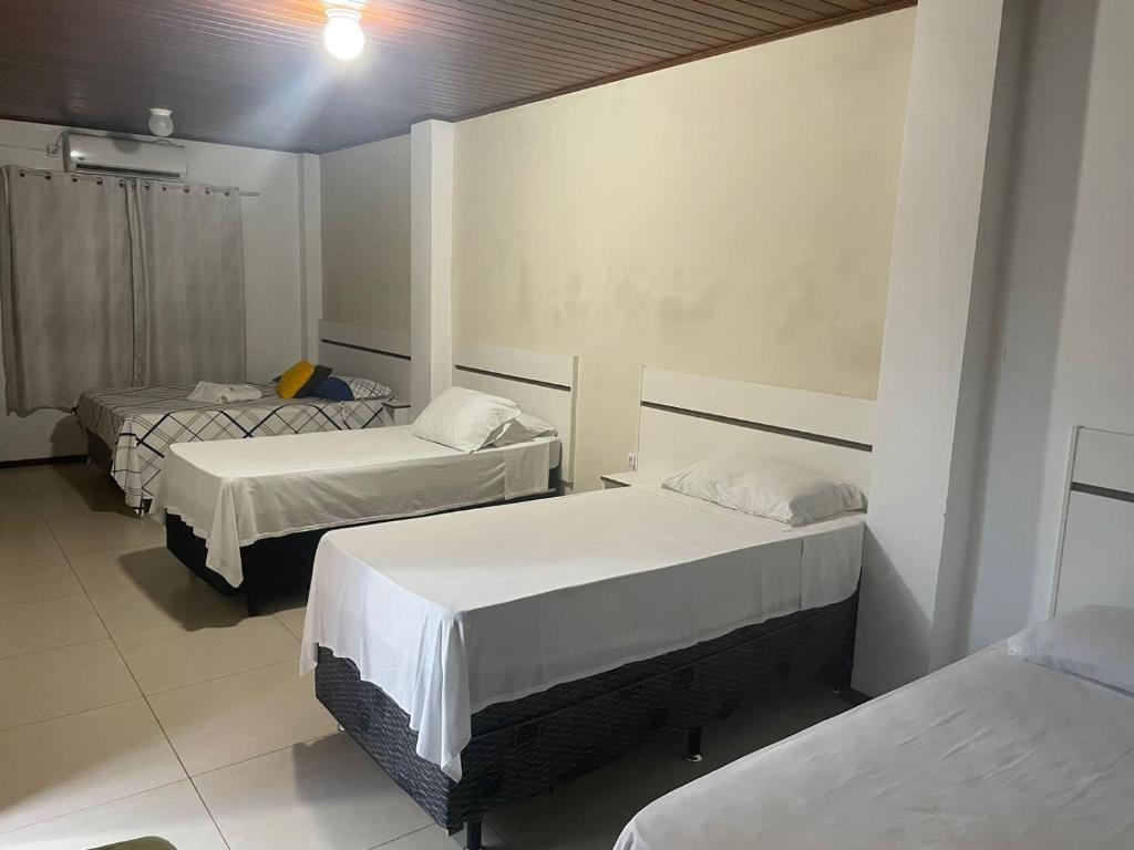Habitación con 3 camas en una habitación en Central 2 - Pousada, en Uruguaiana