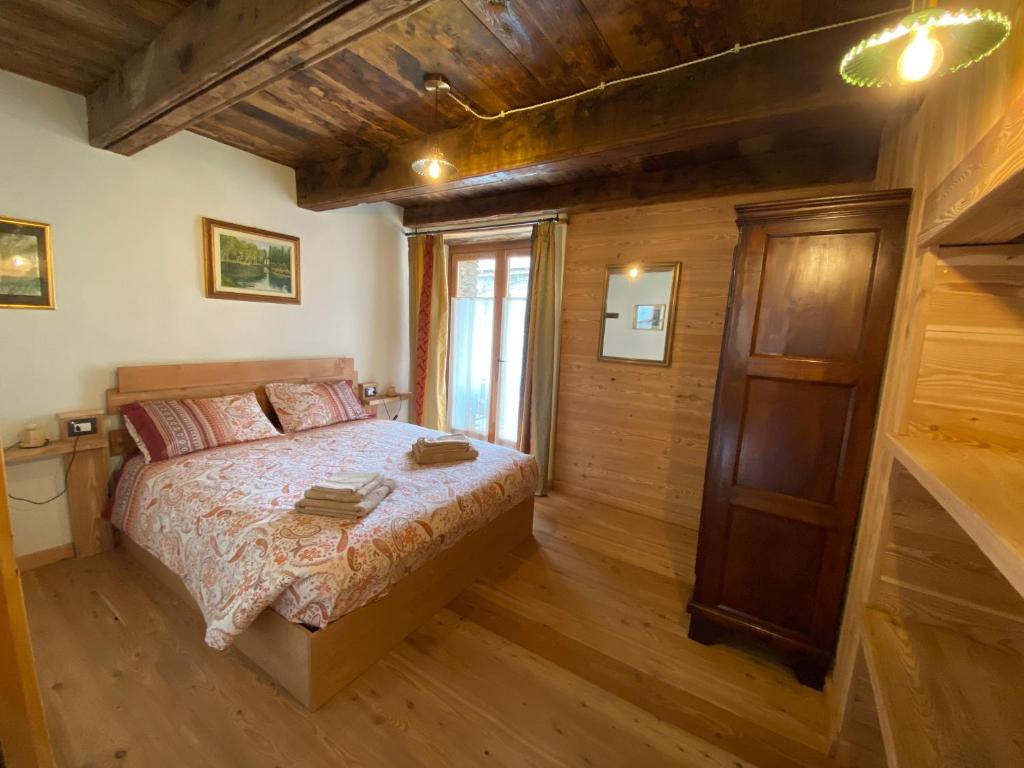 a bedroom with a bed in a room with wooden walls at L'Oasi di Sodani1 in Sampeyre