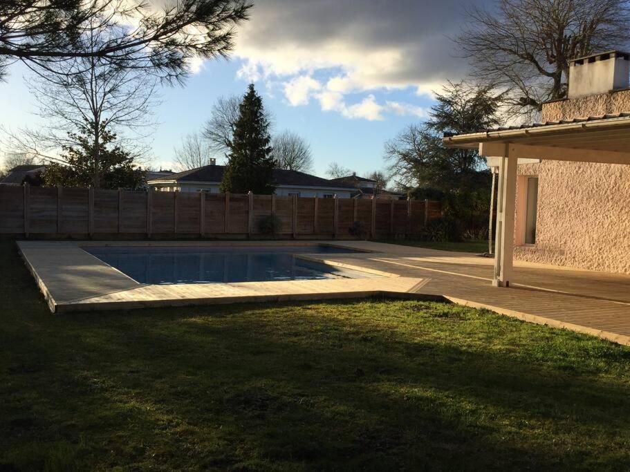 uma piscina num quintal ao lado de uma cerca em Maison d'architecte paisible em Cestas
